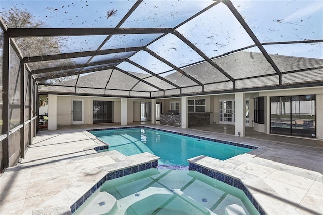 view of pool with an in ground hot tub, glass enclosure, and a patio area