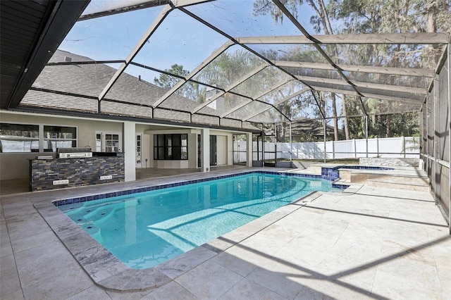 view of swimming pool with a patio, an outdoor kitchen, an in ground hot tub, a lanai, and an outdoor bar