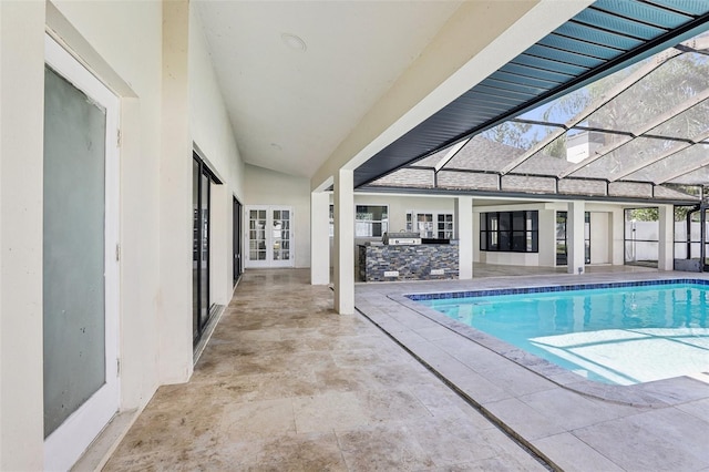 view of swimming pool featuring a lanai, an outdoor bar, and a patio area