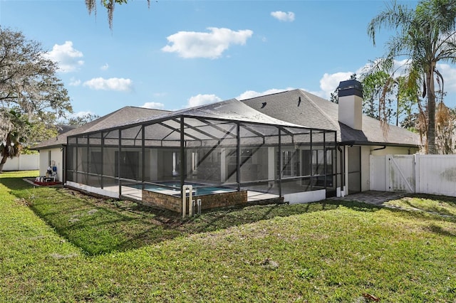 back of house with a fenced in pool, a lanai, and a lawn