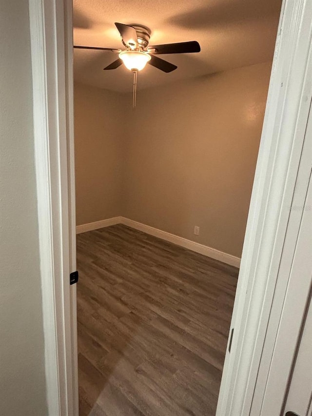 unfurnished room with dark wood-type flooring, a textured ceiling, and ceiling fan