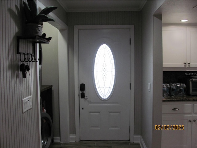 foyer entrance with ornamental molding and hardwood / wood-style floors