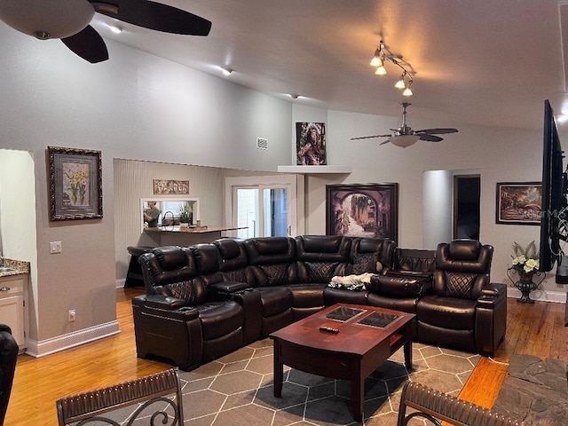 living room with vaulted ceiling, ceiling fan, and light hardwood / wood-style flooring