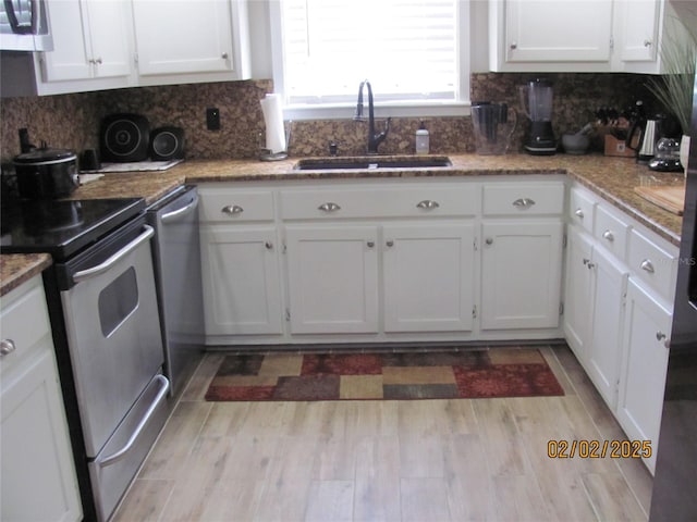 kitchen featuring stainless steel appliances, tasteful backsplash, sink, and white cabinets