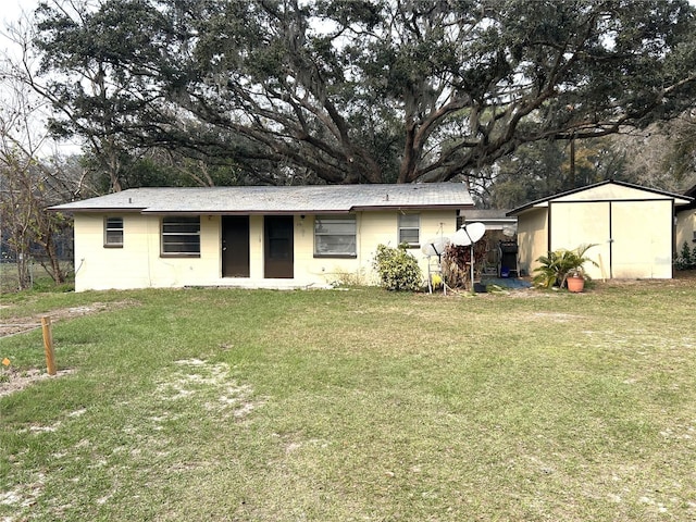 exterior space with a storage unit, a front lawn, an outdoor structure, and concrete block siding