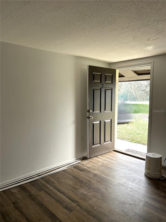 foyer entrance featuring dark wood-style floors and a textured ceiling