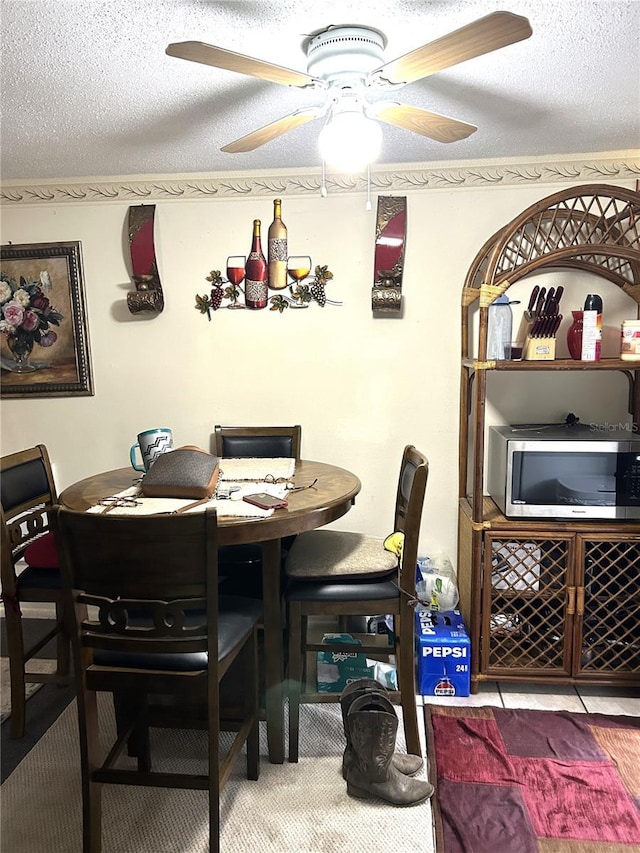 dining space with a textured ceiling and ceiling fan