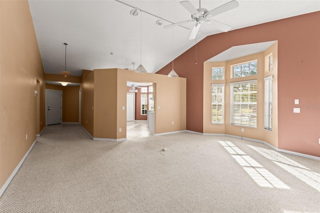 unfurnished living room with high vaulted ceiling, light colored carpet, and ceiling fan