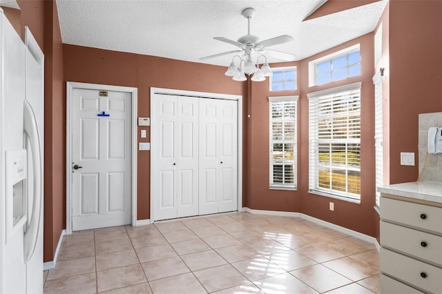 interior space featuring light tile patterned flooring, plenty of natural light, and ceiling fan