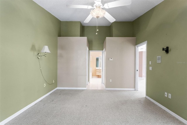 spare room featuring light carpet, a towering ceiling, and ceiling fan