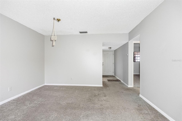 carpeted spare room with a textured ceiling