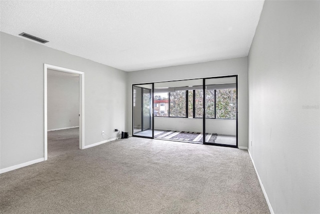 unfurnished room with carpet floors and a textured ceiling