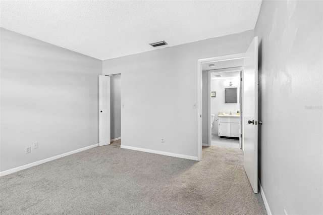 empty room featuring light colored carpet and a textured ceiling