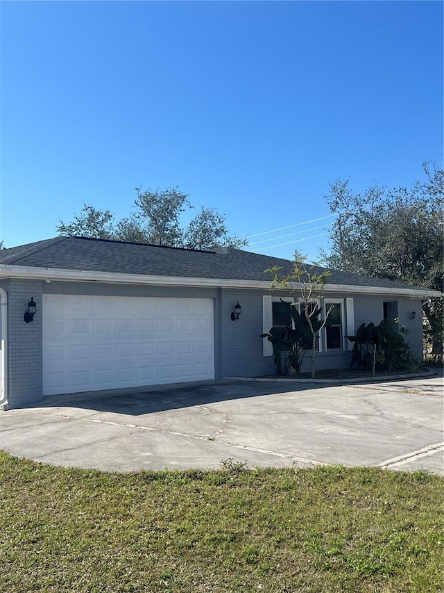 ranch-style house featuring a garage and a front lawn