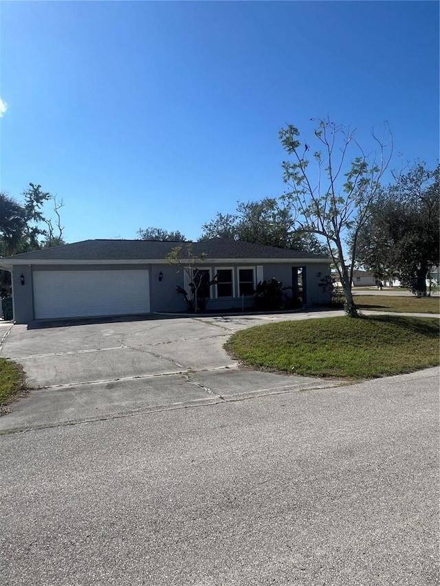 ranch-style home featuring a garage and a front lawn