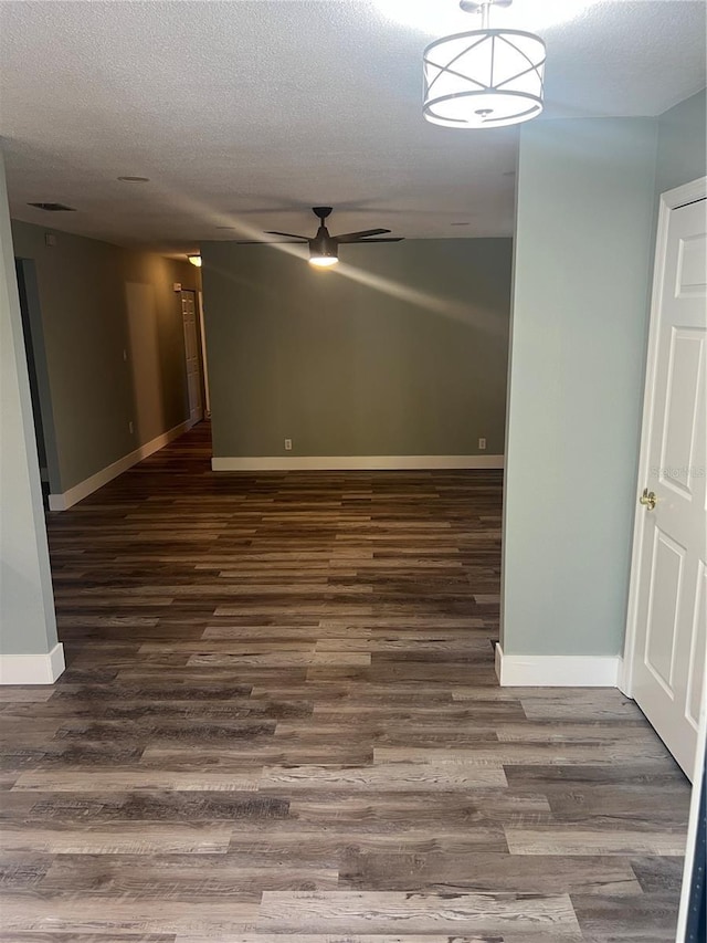 spare room with ceiling fan, dark hardwood / wood-style floors, and a textured ceiling