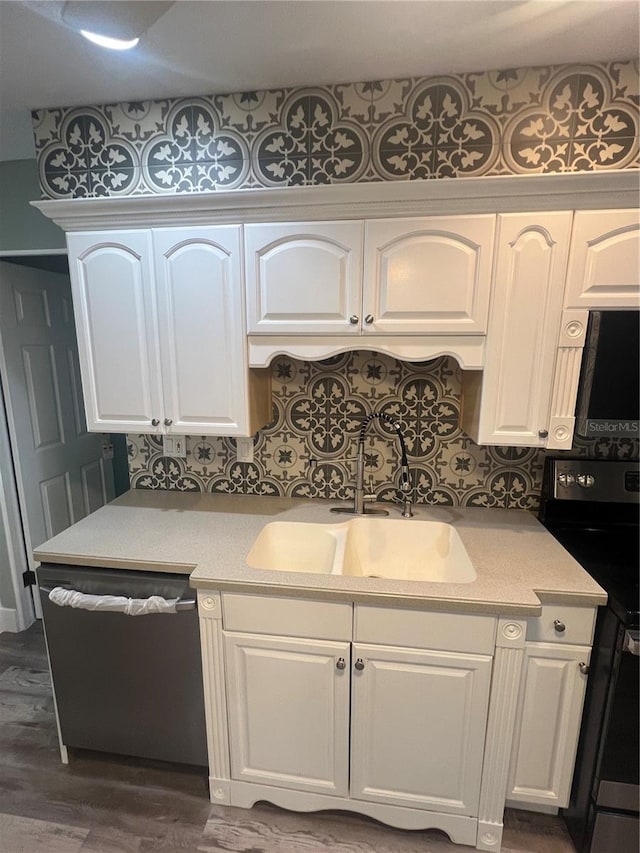 kitchen with black electric range oven, sink, white cabinetry, dishwasher, and backsplash