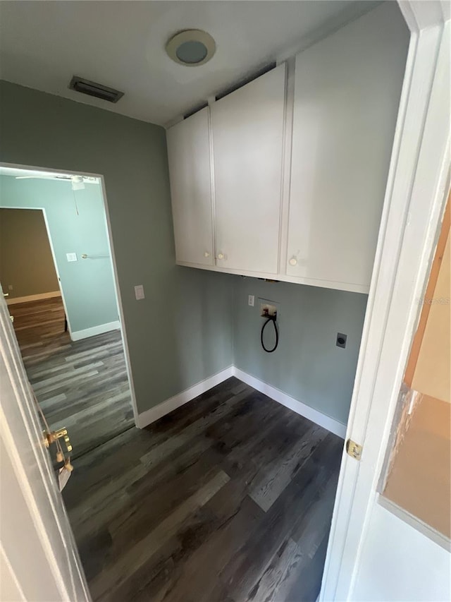 laundry room featuring electric dryer hookup, hookup for a washing machine, dark wood-type flooring, and cabinets