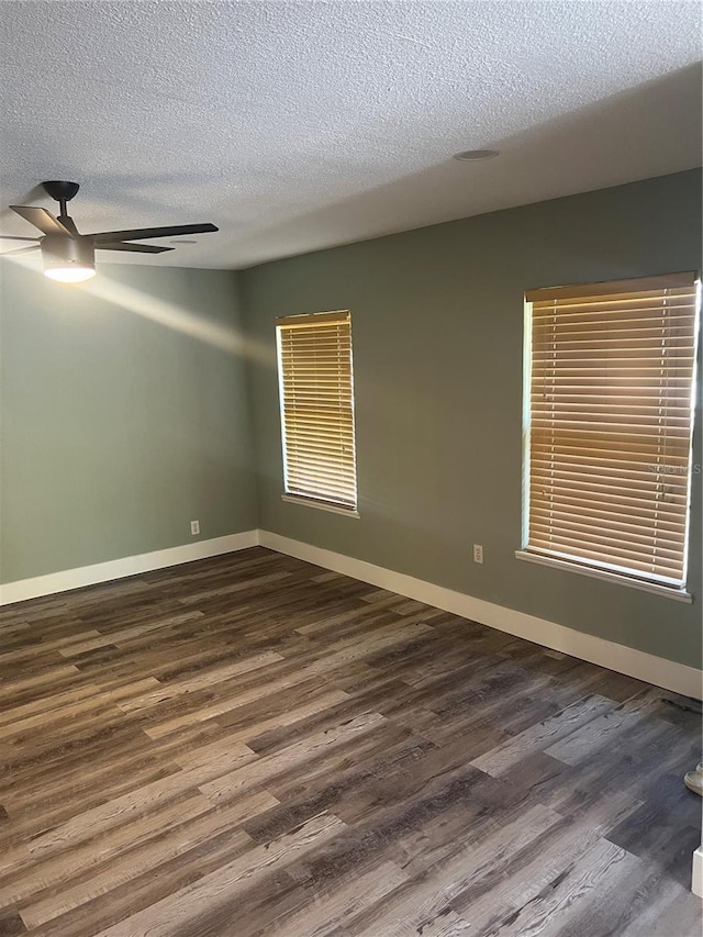 empty room with ceiling fan, a textured ceiling, and dark hardwood / wood-style flooring