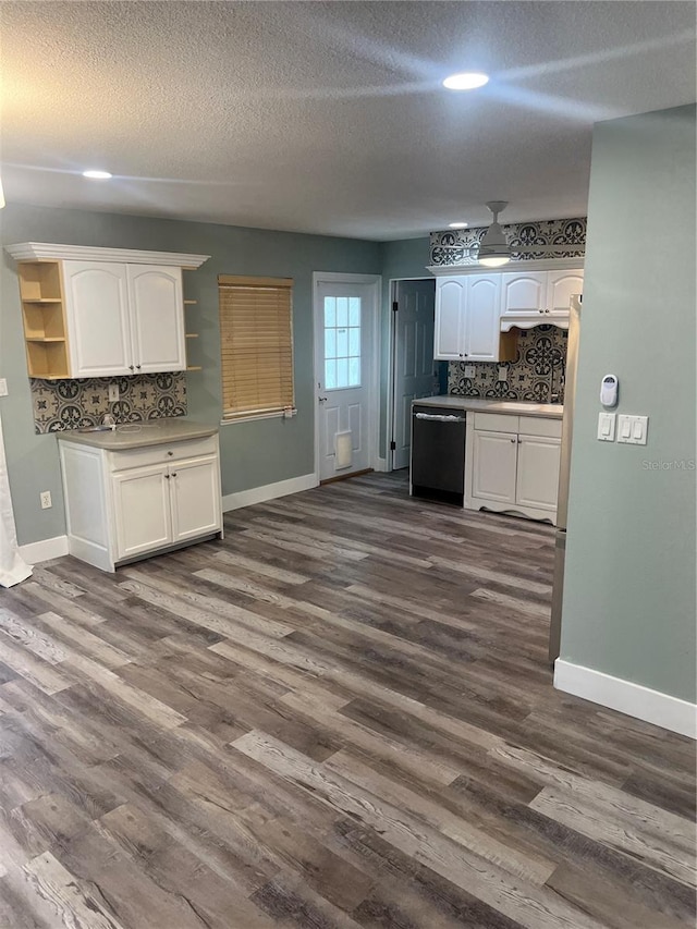 kitchen with dark wood-type flooring, backsplash, black dishwasher, and white cabinets