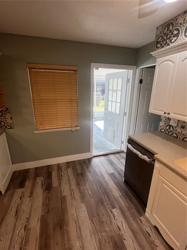 kitchen with black dishwasher, hardwood / wood-style floors, and white cabinets