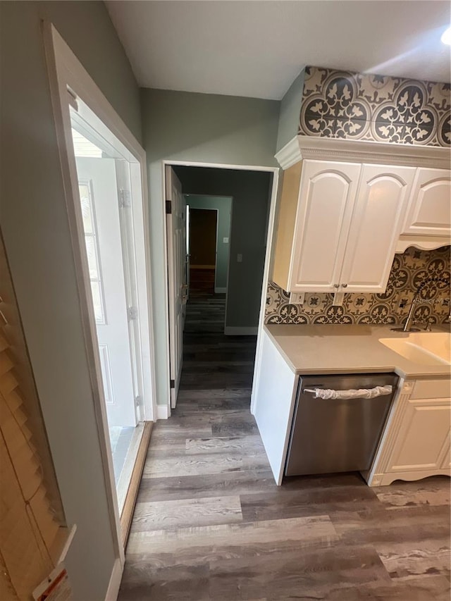 kitchen with white cabinets, hardwood / wood-style flooring, sink, and dishwasher