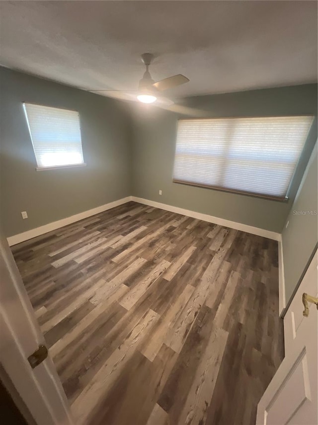 spare room with dark wood-type flooring and ceiling fan