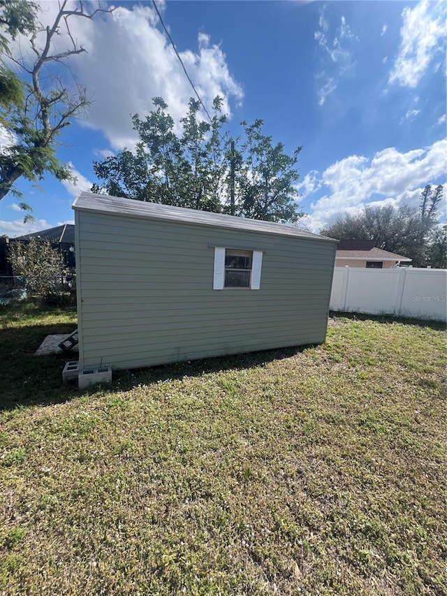 view of side of home featuring an outbuilding and a lawn