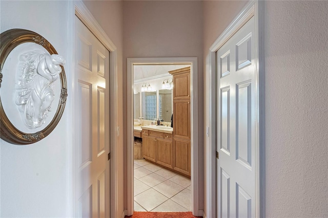 hall featuring light tile patterned flooring and sink