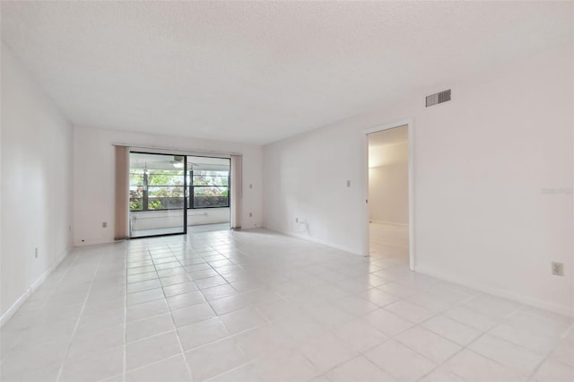 unfurnished room featuring light tile patterned floors and a textured ceiling