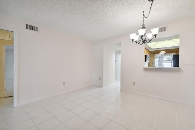 empty room featuring an inviting chandelier and a textured ceiling