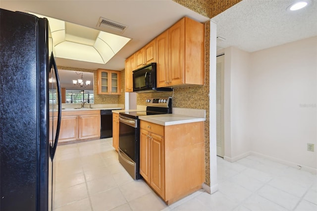 kitchen with sink, an inviting chandelier, black appliances, a textured ceiling, and backsplash