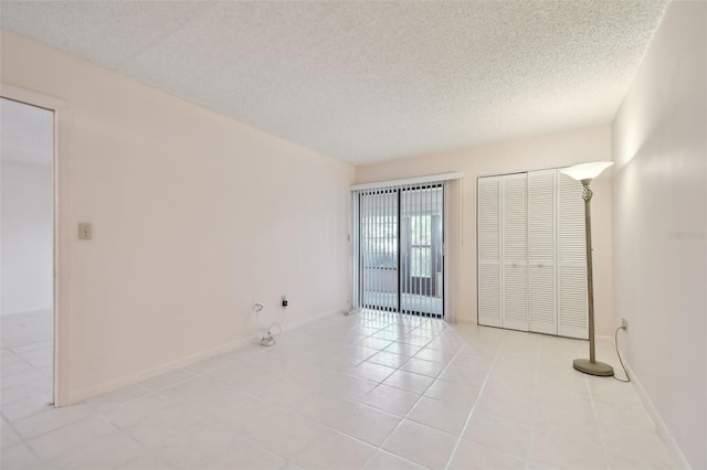 tiled empty room with a textured ceiling