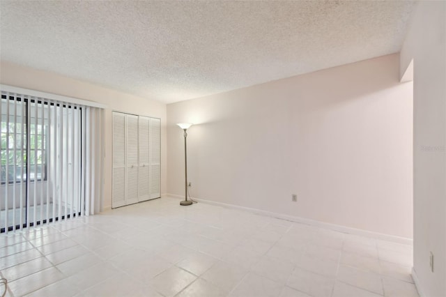 unfurnished room with a textured ceiling