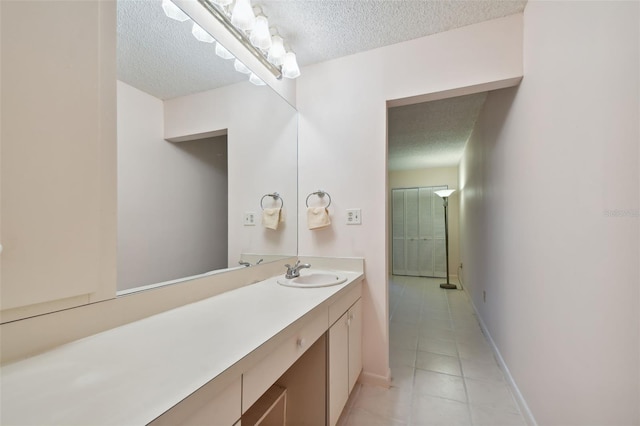 bathroom featuring vanity, tile patterned flooring, and a textured ceiling