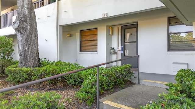 property entrance featuring stucco siding and a porch