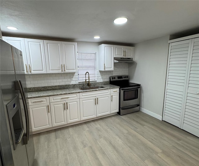 kitchen featuring appliances with stainless steel finishes, sink, backsplash, light hardwood / wood-style flooring, and white cabinetry