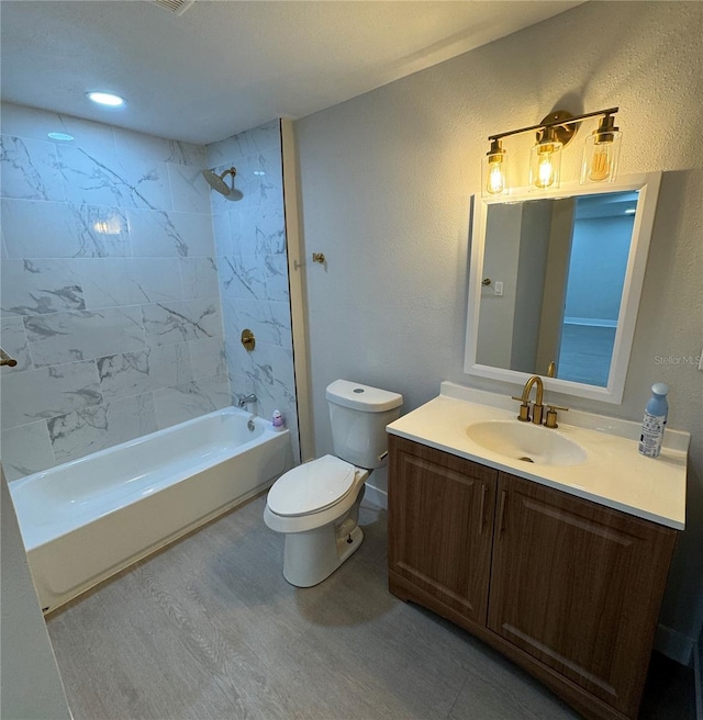 full bathroom featuring hardwood / wood-style flooring, vanity, toilet, and tiled shower / bath