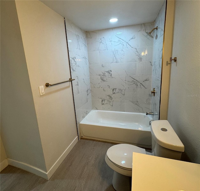 bathroom with toilet, tiled shower / bath combo, and wood-type flooring