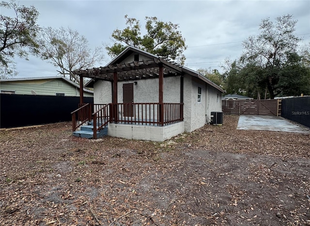 exterior space with central AC unit and a pergola