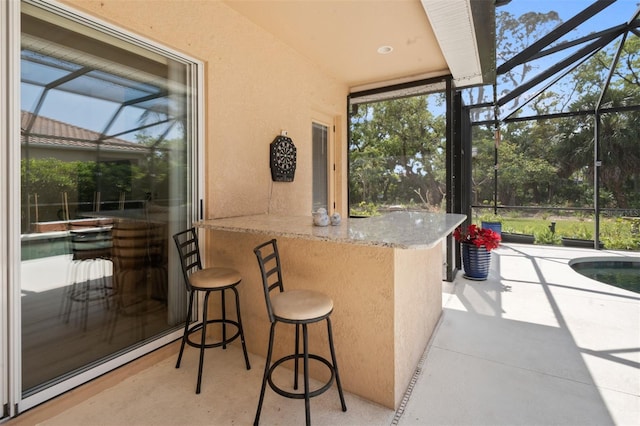 view of patio with a bar, a lanai, and baseboard heating