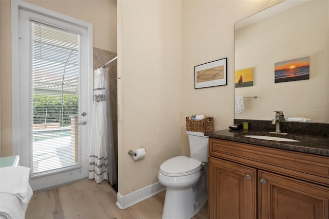 bathroom featuring hardwood / wood-style flooring, vanity, a shower with shower curtain, and toilet