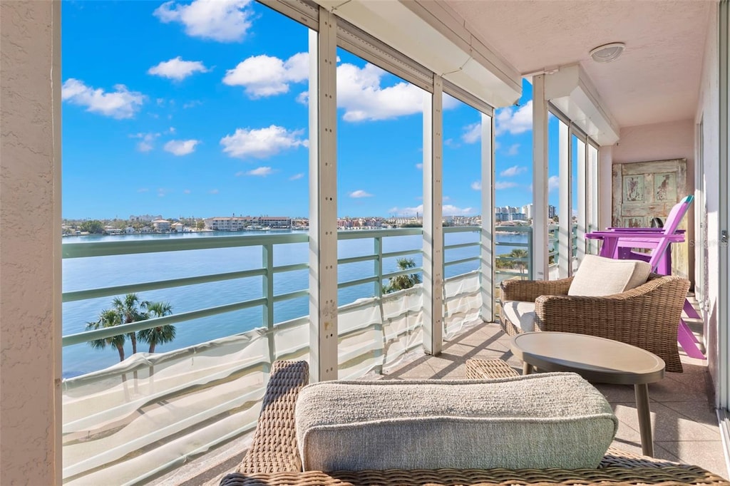 sunroom / solarium featuring a water view and a wealth of natural light