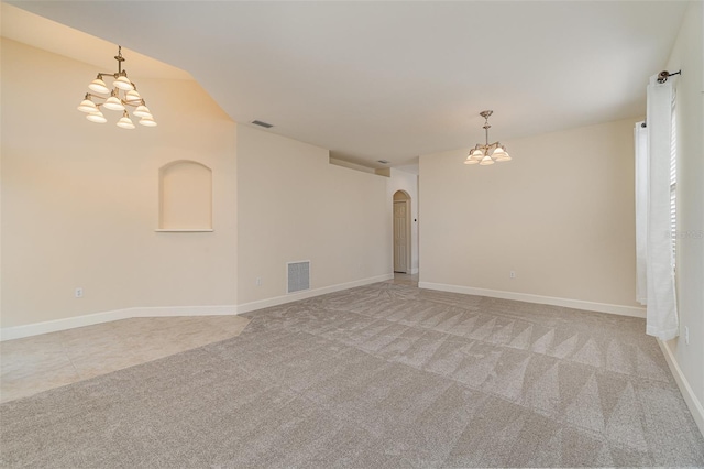 unfurnished room featuring an inviting chandelier and light carpet