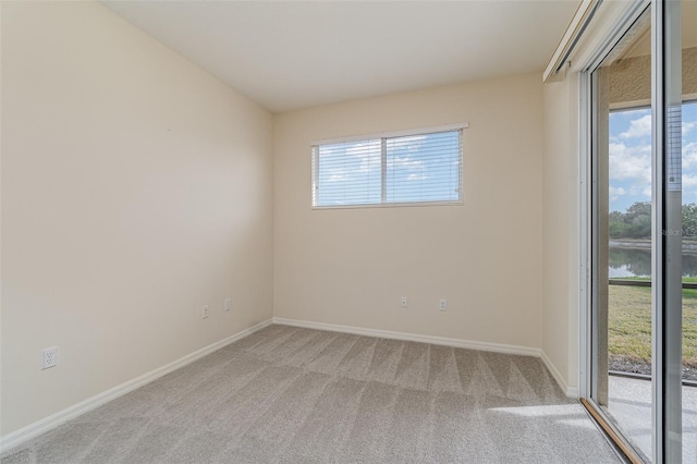 carpeted empty room featuring a water view