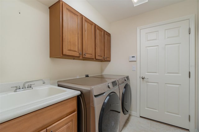 laundry room featuring washer and dryer, sink, light tile patterned floors, and cabinets