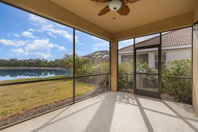 unfurnished sunroom with ceiling fan and a water view