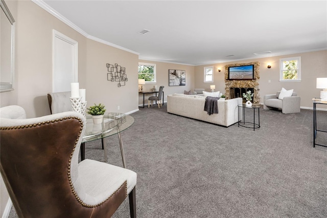 living room with crown molding, a stone fireplace, and carpet flooring