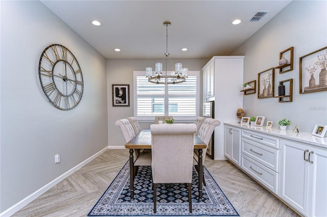 dining room with an inviting chandelier and light parquet flooring