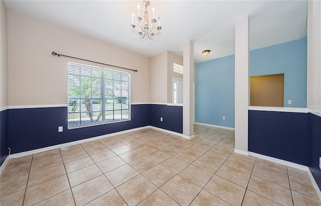 unfurnished room with a chandelier and light tile patterned floors